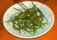 sauteed garlic scapes with roasted pine nuts